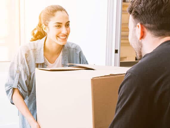 Smiling woman with box talking to van delivery driver